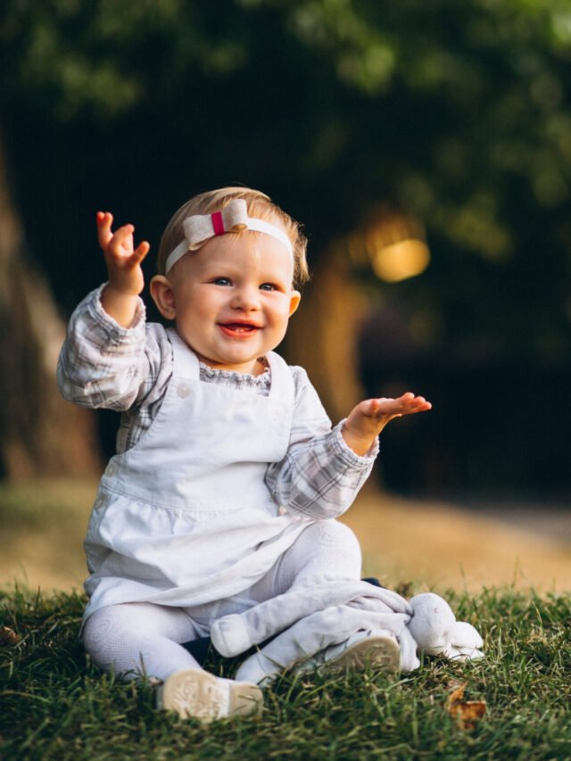 Toddler girl sitting on grass in park
